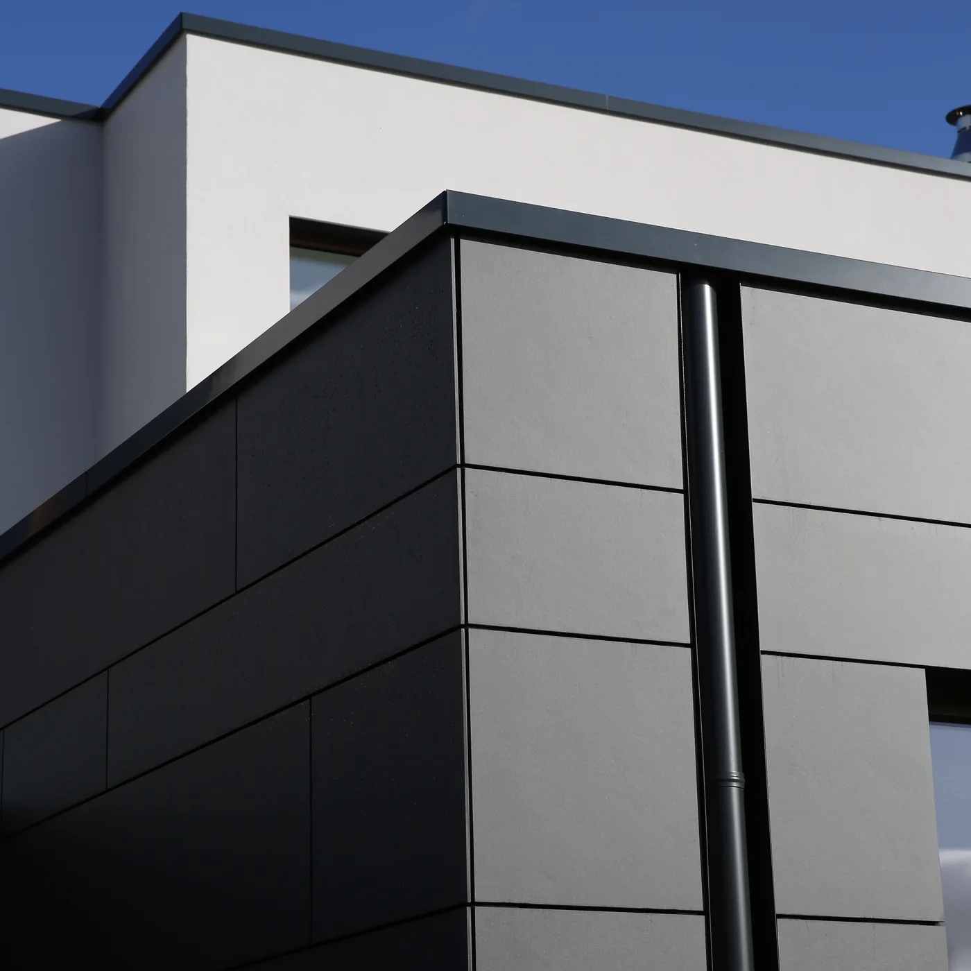 Anthrazitfarbene Fassadenverkleidung an einem modernen Wohnhaus